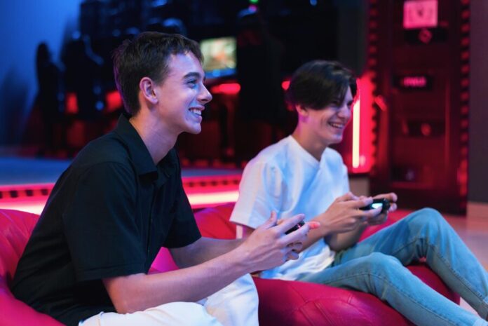two-teen-friends-are-playing-game-console-using-gamepads-smiling-while-sitting-bean_1268-25905 Online sports betting site in Singapore with live odds and updates